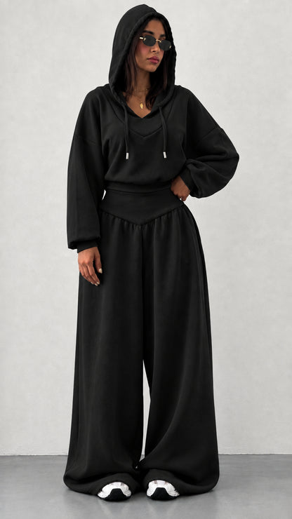 Woman wearing black 2-piece hooded sweatshirt and wide leg pants set