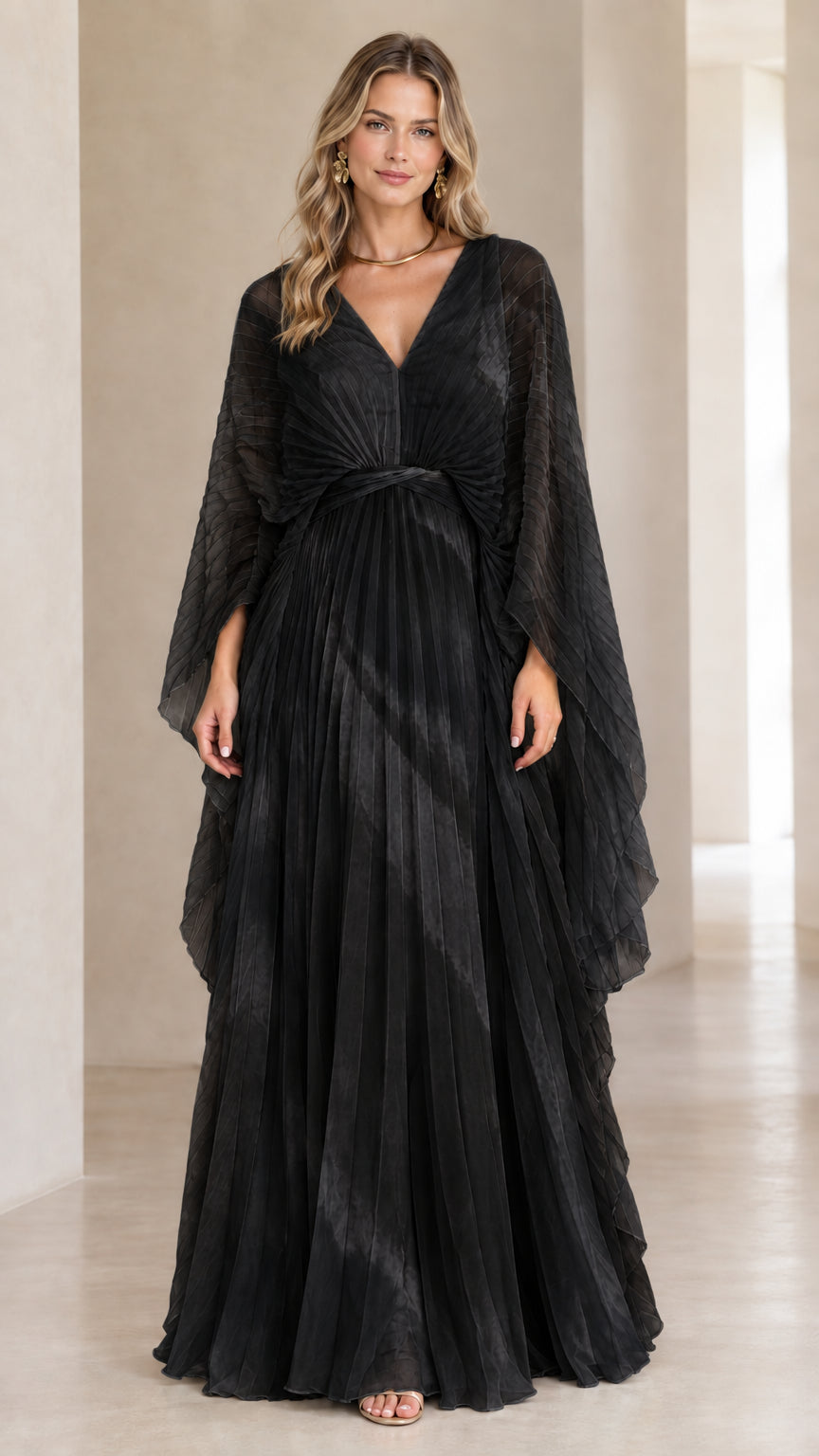 Front view of model wearing black pleated cape sleeve maxi evening gown