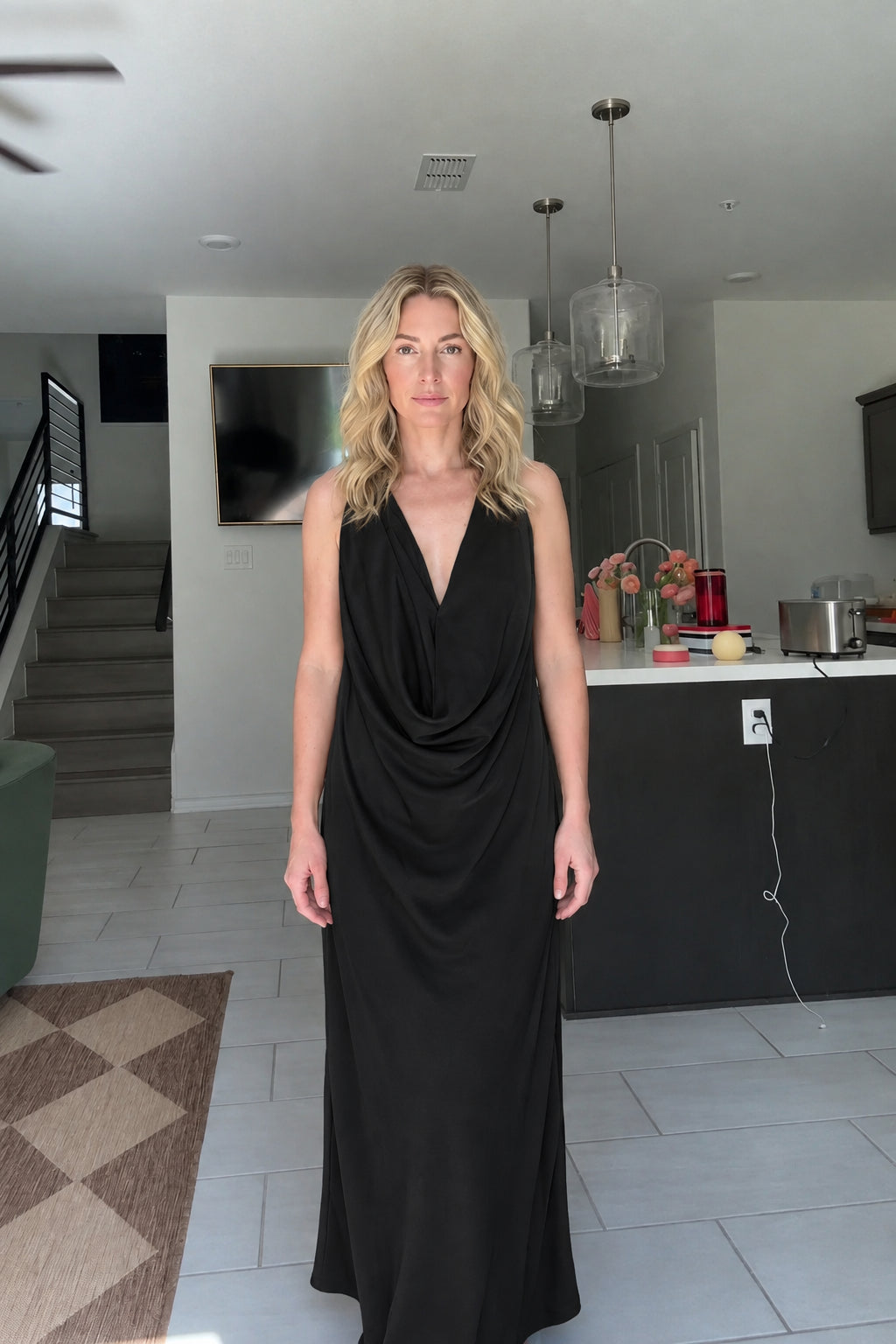 Front view of woman wearing Black draped cowl neck maxi dress
