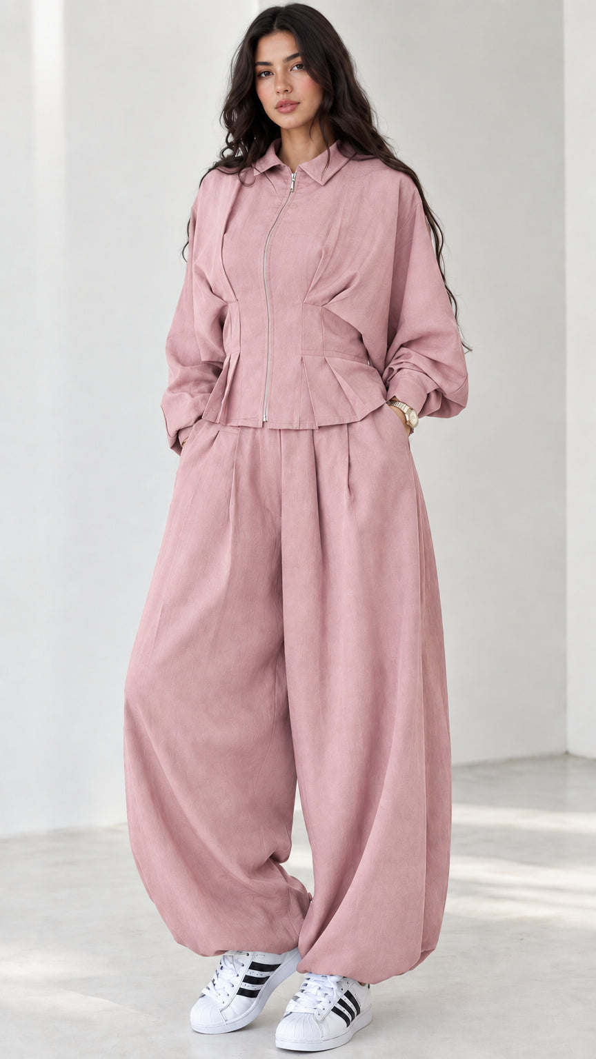 Model wearing dusty pink long-sleeve zip jacket and high-waist balloon pants set