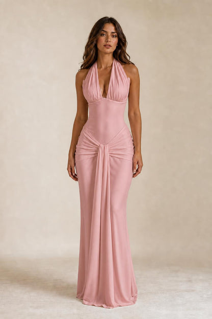 Front view of woman wearing pink draped halter neck maxi dress