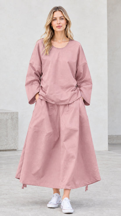 Front view of model wearing dusty pink long sleeve top and maxi skirt set