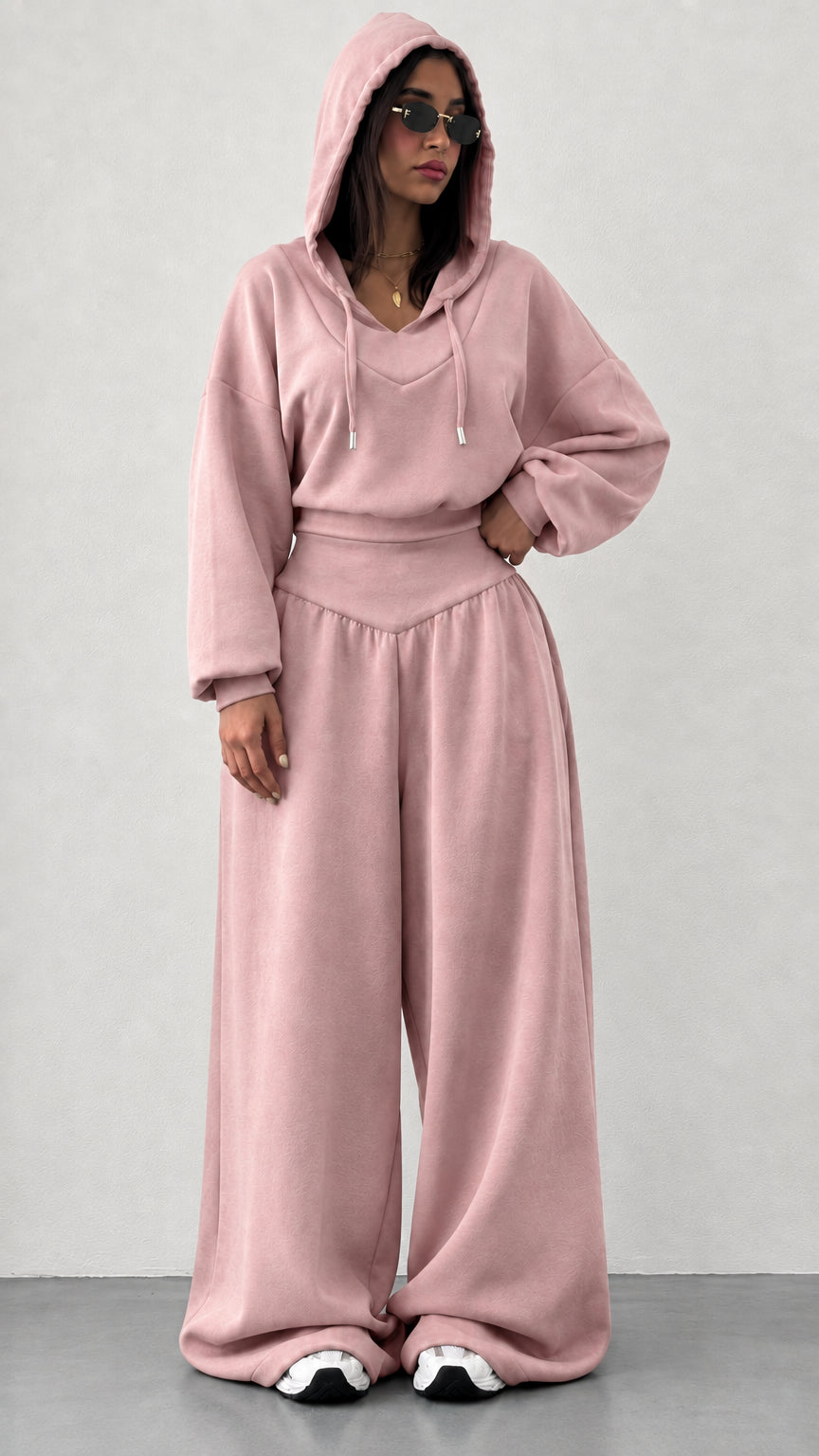 Woman wearing dusty pink 2-piece hooded sweatshirt and wide leg pants set