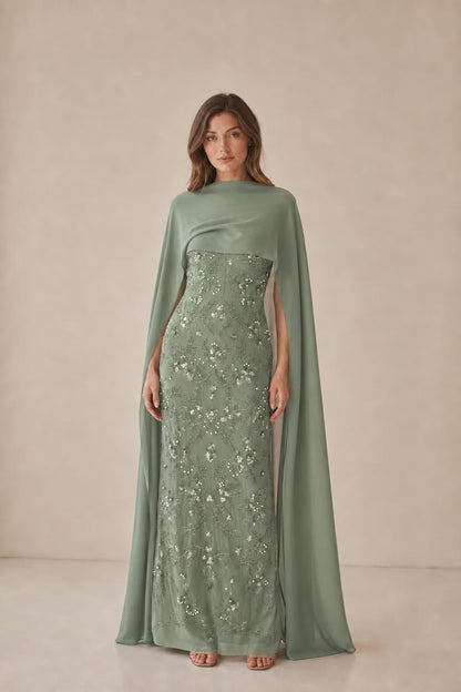 Model wearing sage green formal gown with cape