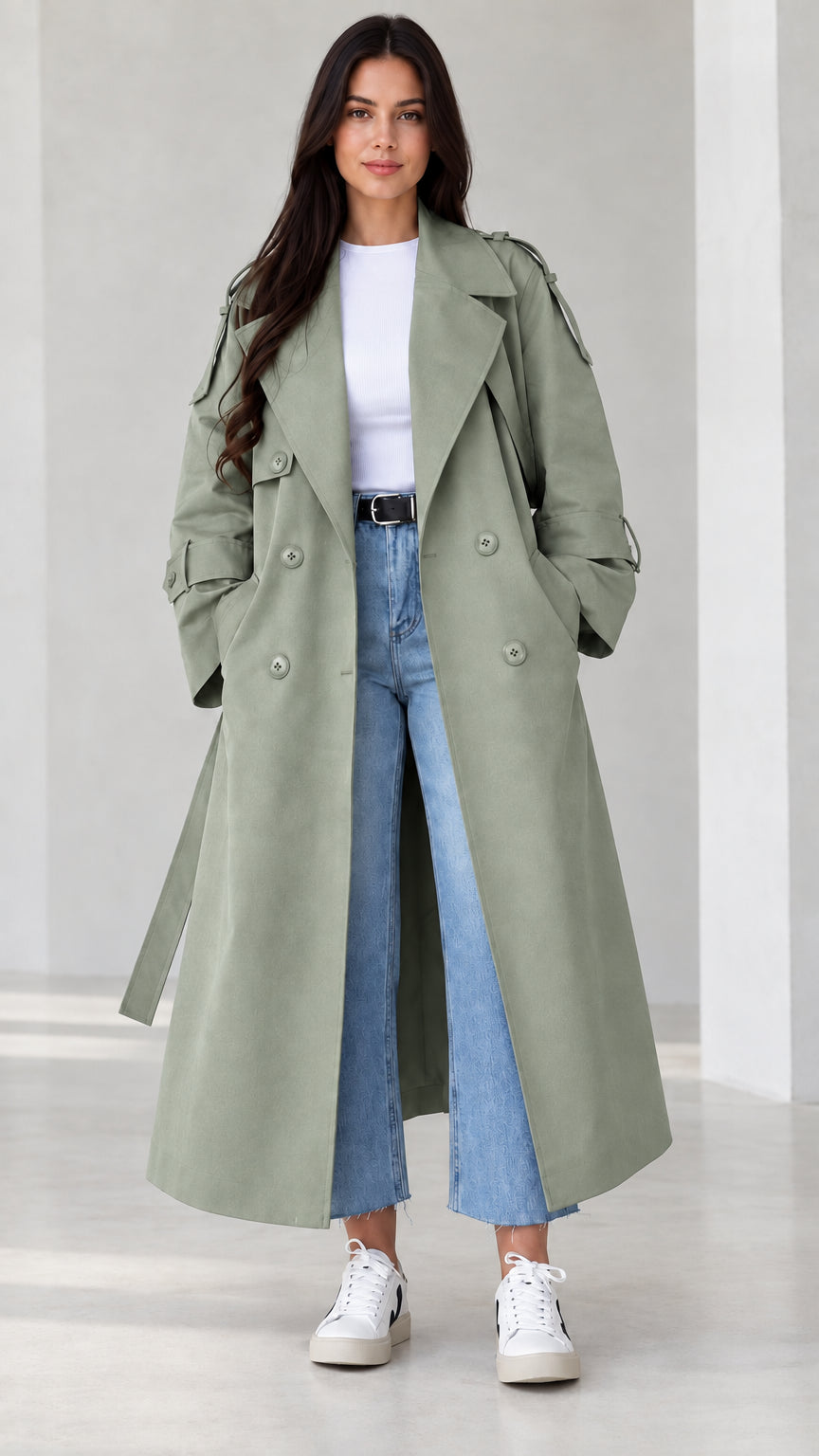 Front view of model wearing sage green maxi trench coat with tie belt