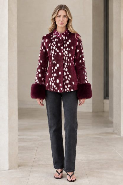 Front view of model wearing burgundy spotted faux fur jacket with plush cuffs