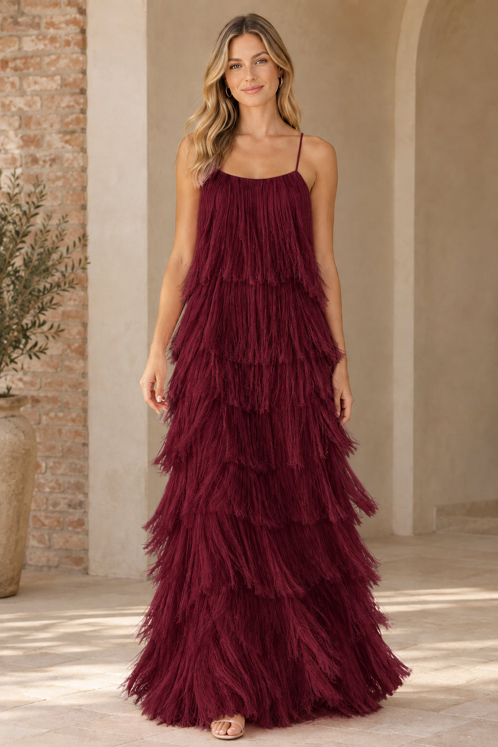 Woman wearing burgundy wine tiered fringe evening gown