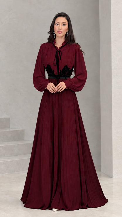 Full front view of burgundy and black long sleeve pleated maxi dress