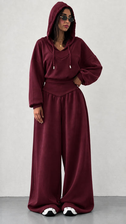 Woman wearing burgundy wine red 2-piece hooded sweatshirt and wide leg pants set