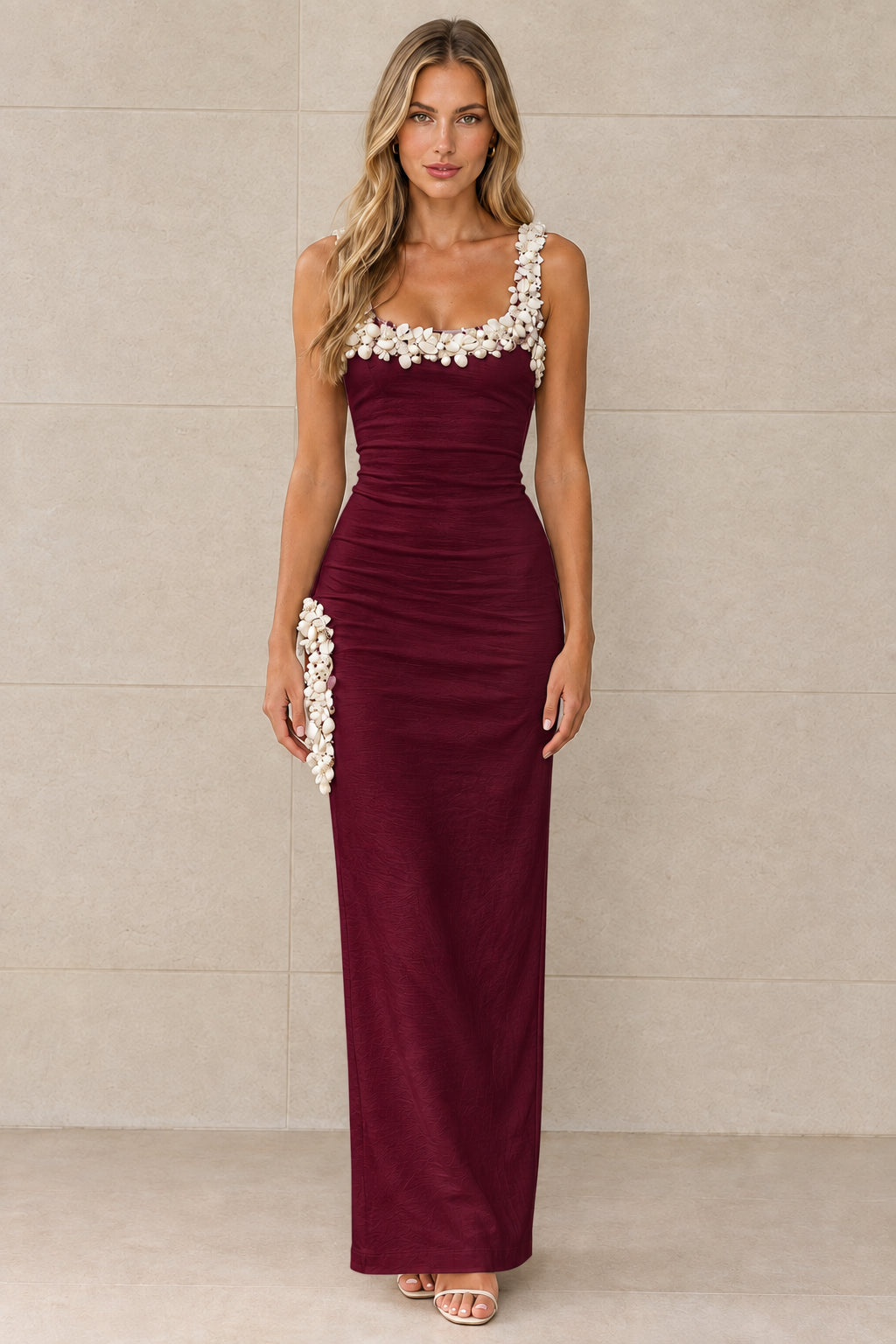 Front view of burgundy sleeveless column maxi dress with white 3D floral accents