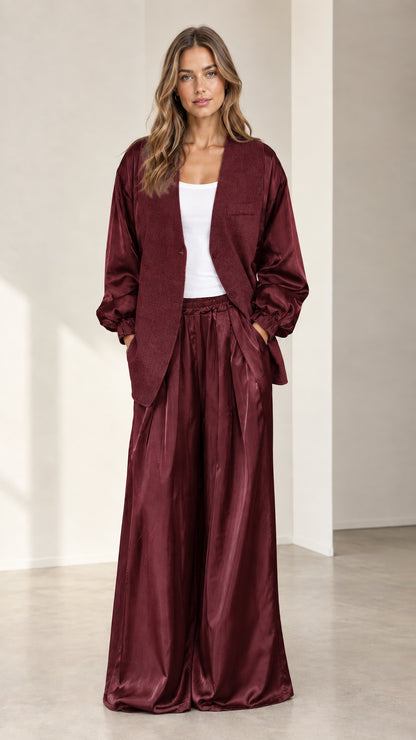 Front view of model wearing burgundy wine satin sleeve blazer and wide-leg trousers set