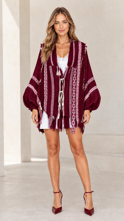 Model wearing deep burgundy embroidered fringe kimono cardigan with contrast stitching