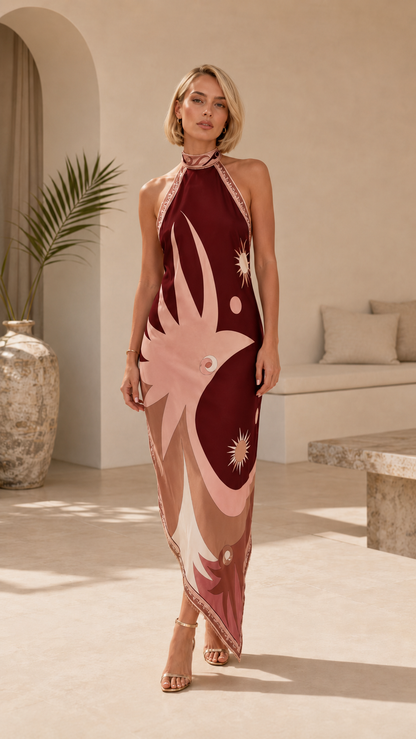 Front view of a wine red abstract print halter maxi dress with pointed hem
