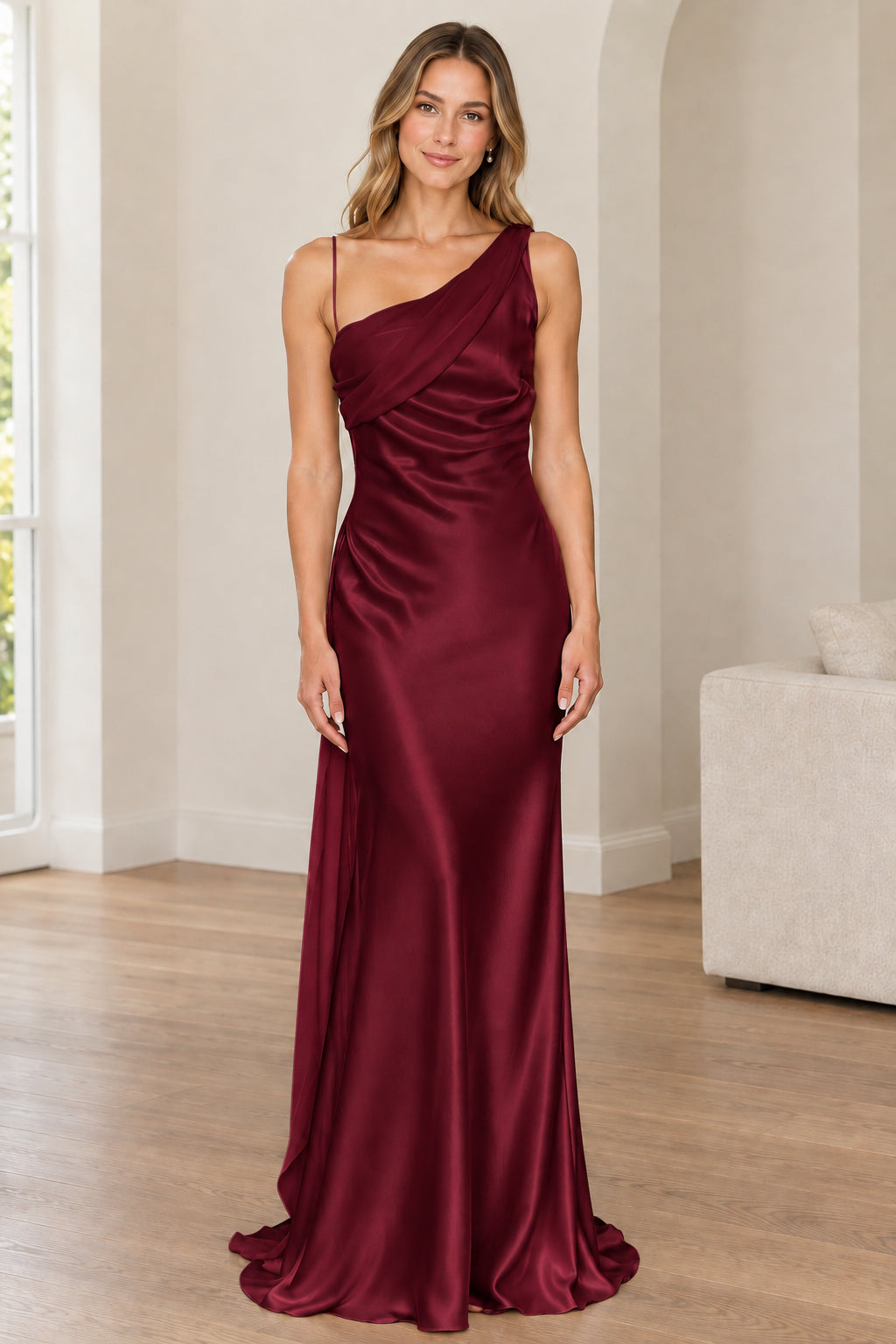 Front full-length view of woman in burgundy red one-shoulder satin gown