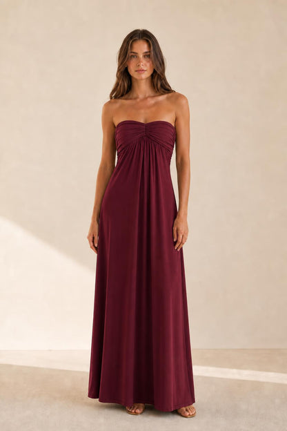 Woman wearing burgundy strapless ruched maxi dress front view