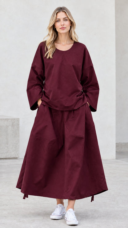 Front view of model wearing rich burgundy matching top and maxi skirt set
