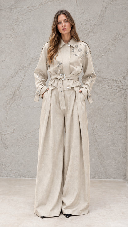 Full front view of model wearing beige embellished wide-leg jumpsuit