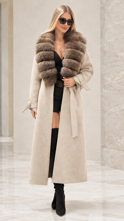Front full view of woman wearing beige cream longline trench coat with faux fur collar