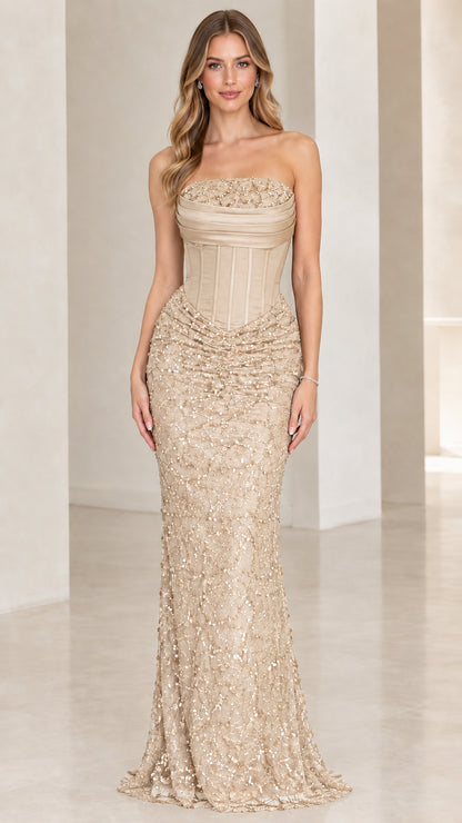 Front view of woman wearing champagne gold strapless corset sequin gown