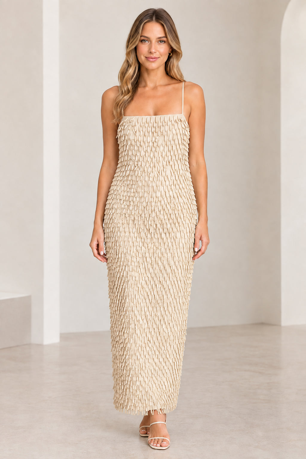 Front view of woman wearing Champagne beige textured fringe spaghetti strap maxi dress